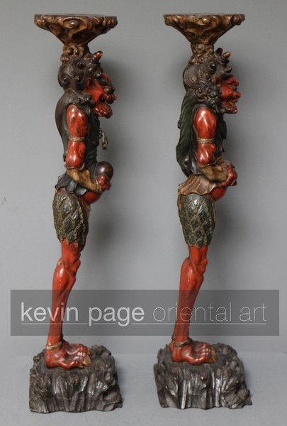 A pair of unusual japanese carved wood candlestick holders in the form of oni