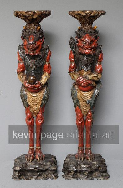 A pair of unusual japanese carved wood candlestick holders in the form of oni