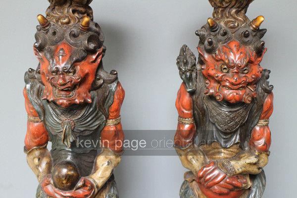 A pair of unusual japanese carved wood candlestick holders in the form of oni