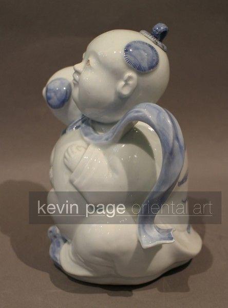 A japanese hirado teapot in the form of a boy with a dog