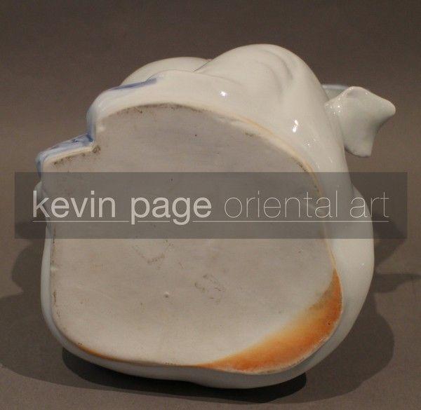 A japanese hirado teapot in the form of a boy with a dog