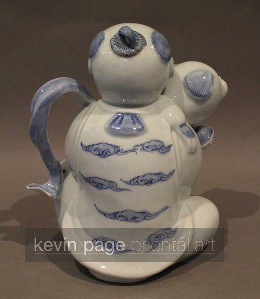 A japanese hirado teapot in the form of a boy with a dog
