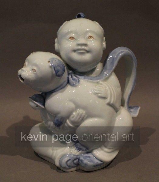 A japanese hirado teapot in the form of a boy with a dog