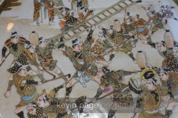 a japanese satsuma plate decorated with a man fighting with a ladder