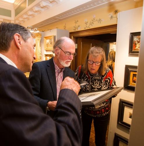 A client examining an etching by Whistler